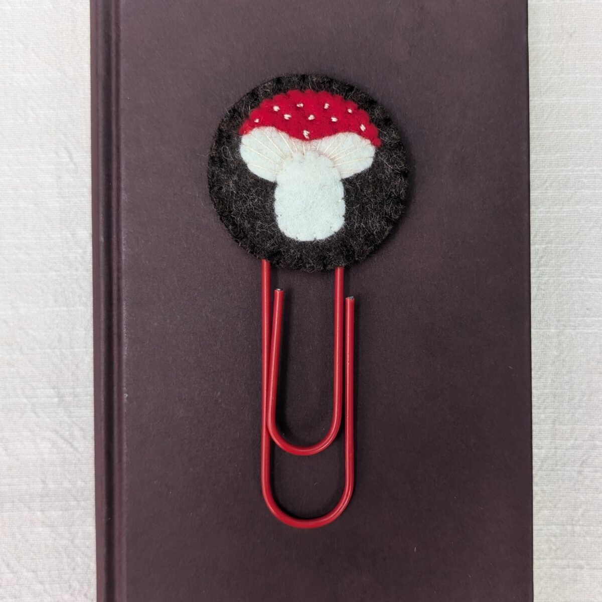 Wool felt topped jumbo paperclip bookmark with hand embroidered and appliqued mushroom motif
